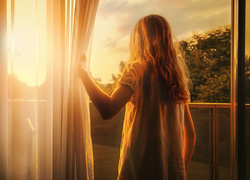 Dziewczynka z balkonu podziwia wschód słońca