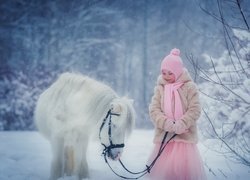Dziewczynka z białym kucykiem w lesie zimą