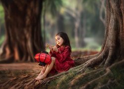 Dziewczynka z lampionem pod drzewem
