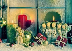 Figurki aniołków i świece w dekoracji przy oknie