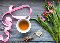 Filiżanka herbaty obok tulipanów