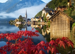Gałązka z czerwonymi liśćmi i widok na miasteczko Hallstatt w Austrii
