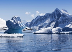Góra lodowa na morzu wśród zimowych gór