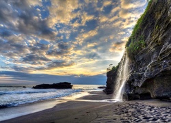 Indonezyjska morska plaża ze skalnym wodospadem na Bali