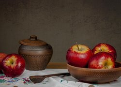 Jabłka w misce obok łyżki i naczynia