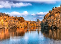 Jezioro otoczone kolorowymi drzewami w barwach jesieni