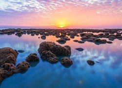 Kamienie na brzegu morza o wschodzie słońca