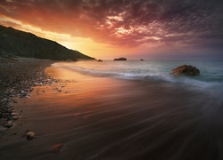 Kamienista plaża na Cyprze o zachodzie słońca