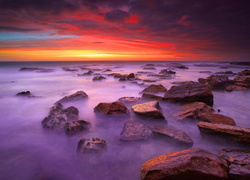 Kamienisty brzeg morza o zachodzie słońca