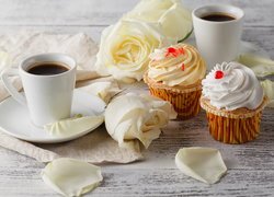 Kawa i babeczki obok białych róż