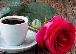 Kawa w filiżance obok róży
