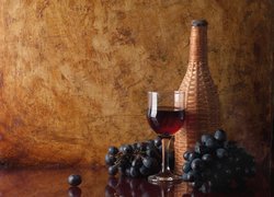 Kieliszek wina koło butelki i ciemnych winogron