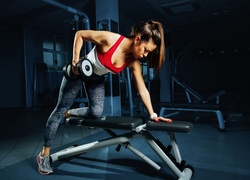 Kobieta na siłowni podczas ćwiczeń z ciężarkiem