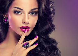 Kobieta o ciemnych włosach w stylowym fioletowym makijażu i biżuterii
