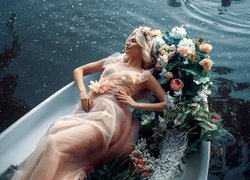 Kobieta obok kwiatów w łódce