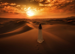 Kobieta podziwiająca zachód słońca na pustyni