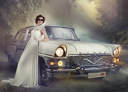 Kobieta w białej sukni oparta o samochód Gaz-13 Czajka