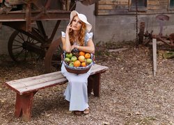 Kobieta w kapeluszu z koszem owoców