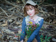 Kobieta w kapeluszu z polnymi kwiatami