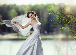 Kobieta w sukni ślubnej z rozwianym welonem
