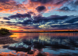 Kolorowe chmury zachodzącego słońca nad jeziorem