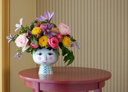 Kolorowe kwiaty w ozdobnym wazonie na stoliku