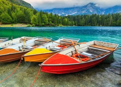 Kolorowe łódki nad brzegiem jeziora Fusine