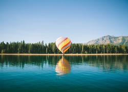 Kolorowy balon nad jeziorem
