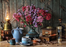 Kompozycja bukietu kwiatów z zestawem do kawy i lampą naftową