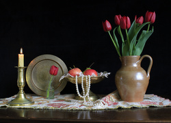 Kompozycja bukietu tulipanów obok patery z jabłkami i palącą się świecą