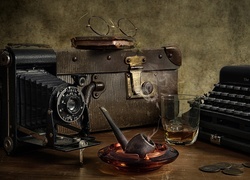 Kompozycja ze starym aparatem fotograficznym walizką i maszyną do pisania