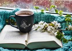Kubek kawy na otwartej książce