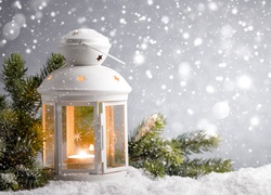 Lampion z gałązkami na śniegu