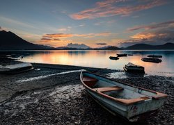 Łódki przy brzegu jeziora o wschodzie słońca
