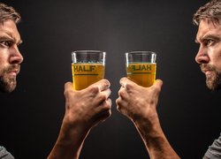 Lustrzane odbicie mężczyzny ze szklanką piwa w dłoni