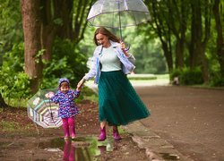 Mama i córka pod parasolem na spacerze w parku