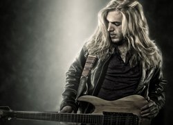 Mężczyzna o długich włosach z gitarą