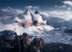 Mgła i chmury nad ośnieżonymi szczytami Dolomitów