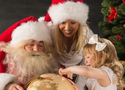 Mikołaj, Śnieżynka i dziewczynka wskazująca miejsce na globusie