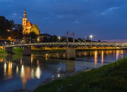 Most i oświetlony kościół nad rzeką Salzach w Salzburgu