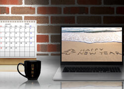Napis Happy New Year na laptopie obok kalendarza na 2024 rok