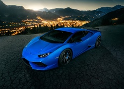 Niebieskie Lamborghini Huracan na tle świateł miasta nocą
