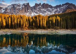 Odbicie rozświetlonych drzew i Dolomitów w jeziorze Lago di Carezza