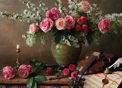 Okwiecone gałązki i róże w wazonie obok skrzypiec