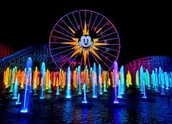 Oświetlony diabelski młyn i fontanny w kaliforniskim Disneylandzie