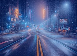 Padający nocą śnieg w mieście