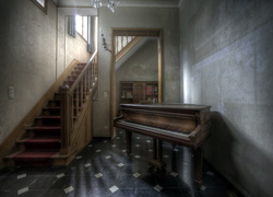 Pianino stojące w korytarzu obok schodów