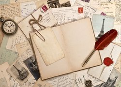 Pióro i zegarek kieszonkowy położone na starych zdjęciach i listach