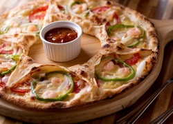 Pizza z dodatkami położona na desce
