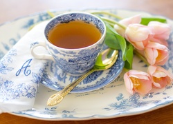 Porcelanowa filiżanka z herbatą i tulipany w kompozycji